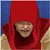 A pixelated figure in a red hooded cloak with a blue background and beige lower section, face partially obscured by pixelation.