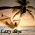 A beach scene with palm trees, a sunset sky, and ocean waves featuring the text "Lazy Days" at the bottom.