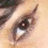 A close-up of a human eye with visible eyelashes and eyebrow, accompanied by red pixelated text on black background reading "You won't ever see what lies behind my eyes...".