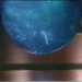 A static, pixelated blue sphere with subtle highlights and a faint white streak on its surface against a blurred background.