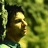 Pixelated close-up of a person's face in profile against green foliage background with visible pixelation and color banding.