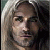 A pixelated close-up of a person with light-colored hair, dark eyes, and a neutral expression against a dark background.