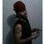 Pixelated image of a person with brown hair wearing a dark sleeveless top, holding a small object against a gray background.