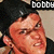 A pixelated image of a person with dark hair and a black shirt, with the text 'bobby' above the head.