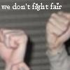 Pixelated text reads 'we don't fight fair' above two blurred fists in a raised position against a striped background.
