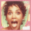 A pixelated image of a person with short curly hair in two sequential poses: first facing forward with mouth open, then covering eyes with both hands while still smiling.
