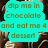 A turquoise speech bubble with brown pixelated text reading "dip me in chocolate and eat me 4 desser" against a blurred background of brown and white shapes.