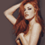 Static pixelated image of a woman with long red hair posing against a solid gray background, rendered in low-resolution style typical of early 2000s digital art.