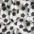 Static pixelated pattern of irregular dark gray and black shapes scattered across a light gray background with subtle white highlights.