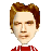 Pixelated portrait of a person with brown hair, light skin, and a red-and-white checkered shirt against a gray background.