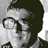 Pixelated grayscale image of a person's face with dark hair and glasses, displayed as a static buddy icon.