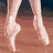 A pixelated image of a person's lower legs and feet in ballet shoes on a wooden floor, with one foot extended forward.