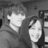 Black-and-white photo of two people in a hooded garment, with pixelated text on black and gray backgrounds.