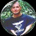 Circular profile image of a person in a blue shirt with white text, set against a green leafy background, displayed in a four