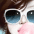 A person with brown hair wearing white sunglasses and pink lips, shown in a of four with subtle facial expression changes