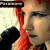 A person with long red hair and dark clothing appears in a of four showing subtle facial expression changes