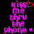 Pixelated text reads 'kiss me thru the phone' in pink with a red heart symbol above 'kiss' and a small pink heart below 'phone' on a black background.