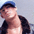A 50x50 pixel animated contact sheet showing three frames of a person in casual attire with visible chest and torso, wearing a blue cap, black jacket, orange pants, and necklaces.