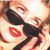 Pixelated close-up of a person's face with red lips, dark hair, and light skin tones, showing partial eyes and mouth.