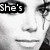 Black-and-white collage of a person's face with text overlays, including "She's blonde and she's bisexual" in pixelated fonts.