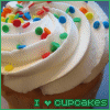 A cupcake with white frosting and colorful sprinkles, with text below reading "I ❤️ CUPCAKES" in green.