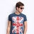 Pixelated image of a person wearing a dark blue t-shirt with a Union Jack design on the chest, standing against a light background.