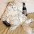 A pixelated white cat with black eyes and nose sits on a beige background, holding a black bottle with a white label in its right paw.