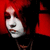 A person with bright red hair and white face paint appears in a of four , with the rightmost showing a blank gray space