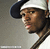 Pixelated static image of a person wearing a white cap and dark jacket against gray background, cropped to show partial face and upper body.