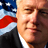 Static 48x48 pixel icon showing a close-up of a person's face with an American flag background, rendered in low-resolution pixel art style.