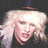 Pixelated close-up of a person with light-colored hair and closed eyes against dark background.