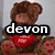 A pixelated teddy bear with red accents wears a heart-shaped scarf, overlaid by text reading "devon" and a green banner stating "No matter what people say I'm going to love him anyway." The right side features repeated red "LOVE" text on white.