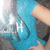 A blue-shirted figure with a light-colored arm and hand, holding a dark object, with white text 'LH' visible on the shirt.