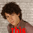 A person with curly brown hair in a brown shirt appears across four , with red text changing from 'this' to 'is' to 'gorgeous' over time