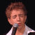 Animated contact sheet of a person singing into a microphone with repeated text "Sing your heart out" in purple and pink pixelated font across multiple frames showing color cycling on the word "heart".
