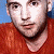 A 50x50 pixel buddy icon split into two frames showing a person in an orange shirt on the left and green text reading "Original Icons .com" on the right, with visible pixelation and dithering effects.