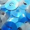 A dense cluster of overlapping circular blue and silver discs with reflective surfaces and central holes, arranged in a tight pattern.