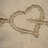 A pixelated heart drawing on sand with text overlays on a blue background.