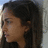 Pixelated profile view of a person with dark hair against light background, showing side face and shoulder in low-resolution static image.