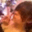 Pixelated image of a person with brown hair and light skin, wearing an orange garment against a blurred background.