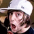 A person wearing a white cap and dark clothing with red accents appears in four showing sequential facial expressions