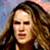 Static pixelated image of a person with long brown hair against a blurred background, rendered in low resolution with visible dithering and color blending.