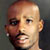 Pixelated close-up of a person's face with smooth skin tones and visible facial features against a dark background.