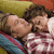 Two people in a close embrace, one lying on a patterned surface with a yellow background element.