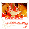 A static image of two people in a close-up pose with red and white clothing, below which is red text and a stylized signature.