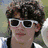 Six views of a person with curly brown hair in various outfits and poses, including sunglasses, a white tank top, and a black jacket.