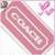 Pink rectangular tag with white border and 'COACH' text, surrounded by small pink hearts on a white background.