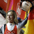 Pixelated static image of a female tennis player in mid-action holding a racket, wearing red and white athletic attire against a blurred background with warm tones.