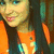 Pixelated close-up of a person with light skin, blue eyes, and dark hair wearing an orange top against a blurred background.