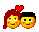Two yellow emoji faces with blue eyes and orange cheeks stand side-by-side under red and pink heart shapes, their hair colors alternating between dark brown and black.
